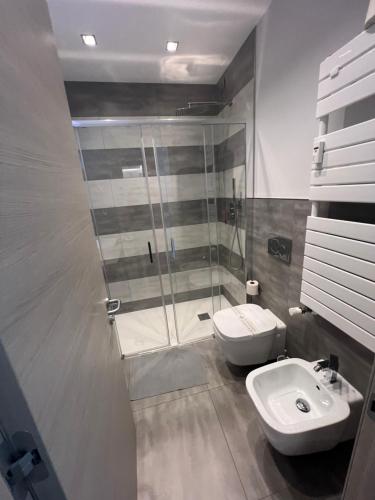 a bathroom with a shower and a toilet and a sink at Eden Rooms in La Spezia