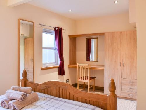 1 dormitorio con 1 cama, 1 silla y 1 ventana en River Cottage - Uk12759, en Milton