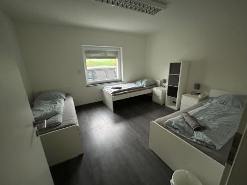a bedroom with two beds and a window at 3 Mehrbettzimmer, Küche, Bad für Arbeiter und Monteure in Gau-Weinheim in Gau-Weinheim
