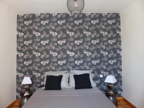 a bedroom with a bed with a floral wallpaper at L'Incarnat in Caunes-Minervois