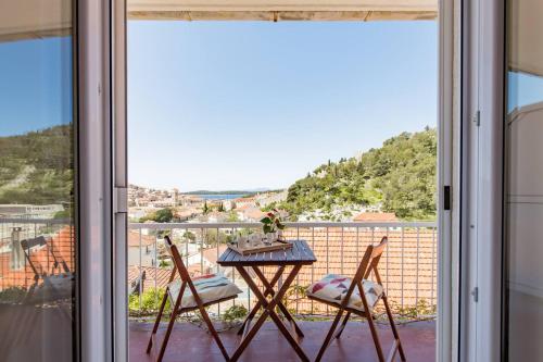 a table and two chairs on a balcony with a view at Guest House Vuljan in Hvar