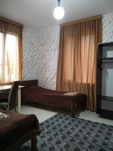 a room with two beds and a flat screen tv at Natalia - Bagrationi St # 42 in K'obulet'i
