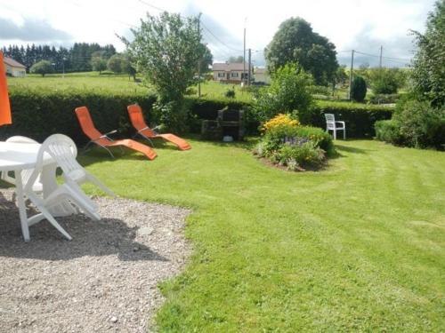 a group of chairs sitting in a yard at Gîte nature, 15 km de Gérardmer, randonnée, ski, jardin, terrasse, BBQ, équipements bébé inclus - FR-1-589-64 in Champdray