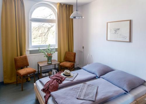 um quarto com uma cama, uma mesa e uma janela em Gasthaus zur Ostbahn em Müncheberg