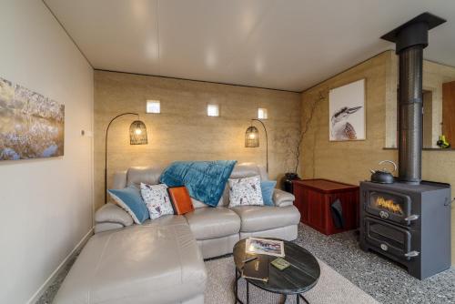 a living room with a couch and a wood stove at Earth & Soul Retreat in Cannon Creek