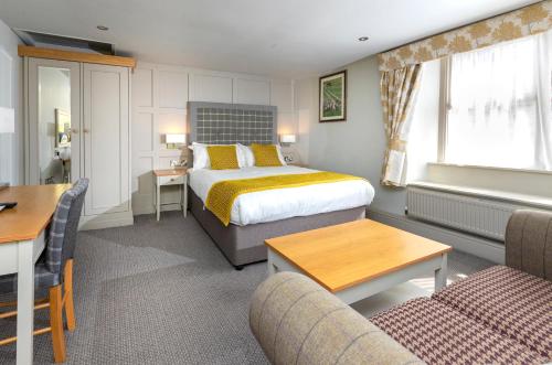 a hotel room with a bed and a table and chairs at The Woolly Sheep Inn in Skipton