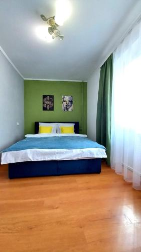 um quarto com uma cama grande e uma parede verde em 3 кімнатна затишна та комфортна квартира em Chernivtsi