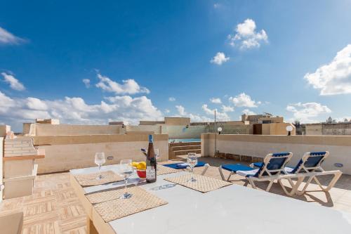 a patio with a table and chairs on a roof at Naduri, Beautiful Gozitan Villa plus Pool - Happy Rentals in Nadur