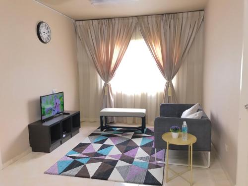 a living room with a couch and a tv at Homestay Wafiy Lost World Tambun Ipoh in Ipoh