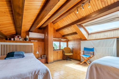 a bedroom with a bed and a chair in a room at Paola: Preciosa casa pareada con piscina in Sitges