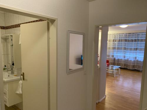 une porte ouverte donnant sur une salle de bains avec un miroir dans l'établissement Ferienappartment Möhnesee, à Möhnesee