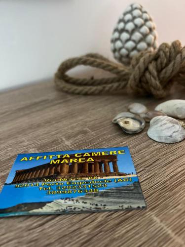 a book sitting on top of a table next to a rope at Marea affittacamere in Porto Empedocle