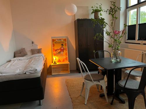 Schlafzimmer mit einem Bett, einem Tisch und Stühlen in der Unterkunft Room 9 -Hawkraft kulturhotel in Vestervig