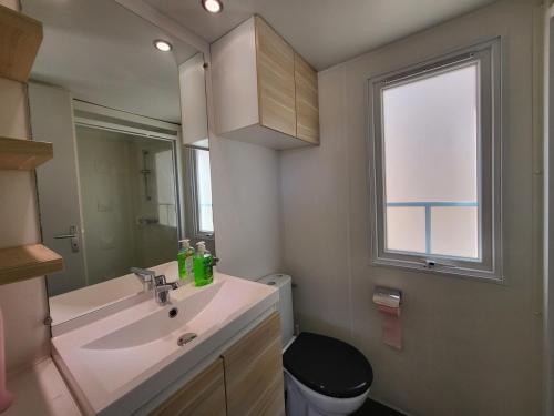a bathroom with a sink and a toilet and a window at Camping Albox in Albox
