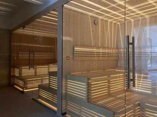 a sauna with wooden floors and a glass wall at Jantar Apartamenty Sunny Olymp I in Kołobrzeg