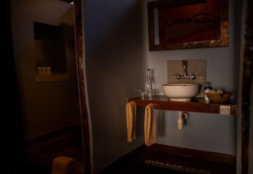a bathroom with a sink and a mirror at Kisima Ngeda Camp in Mangola