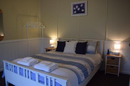 1 dormitorio con 1 cama con toallas en Burr Cottage in Mount Burr, en Millicent