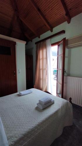 a bedroom with a large white bed with a window at AGNANTIO in Monemvasia