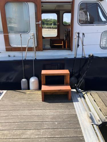 a wooden bench sitting on the side of a boat at La Vedette Hollandaise in Étaples