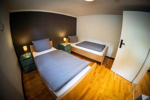 a small room with two beds and two lamps at Gemütliche 2-Zimmer Souterrain Wohnung in Düsseldorf