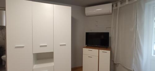 a living room with white cabinets and a tv at Varna Studio 2 in Varna City
