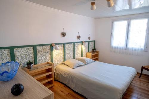 ein Schlafzimmer mit einem großen Bett und einem Tisch in der Unterkunft Cœur de Charente maritime in Saint-Germain-de-Marencennes