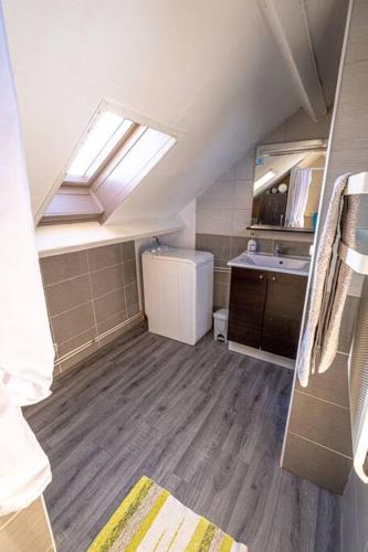 une petite salle de bains avec un lavabo et une lucarne. dans l'établissement Cœur de Charente maritime, le grand horizon, à Saint-Germain-de-Marencennes