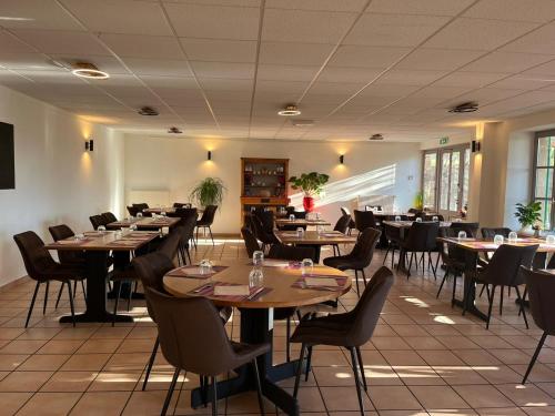 un comedor lleno de mesas y sillas en Gîte - Auberge du Midi en Saint-Antoine