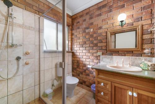 a bathroom with a shower and a toilet and a sink at Coucals Cottage in Mount Crosby