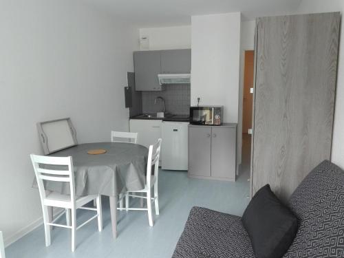une cuisine avec une table et des chaises dans une pièce dans l'établissement Studio rénové avec balcon à 100m de la plage et piscine - 4 personnes - Les Sables-d'Olonne - FR-1-331-204, à Les Sables-dʼOlonne