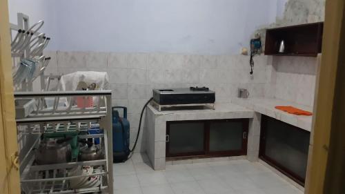 a kitchen with a stove top oven next to a counter at Kallista Homestay in Banyuwangi