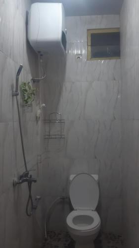 a bathroom with a toilet and a water tank at Kallista Homestay in Banyuwangi