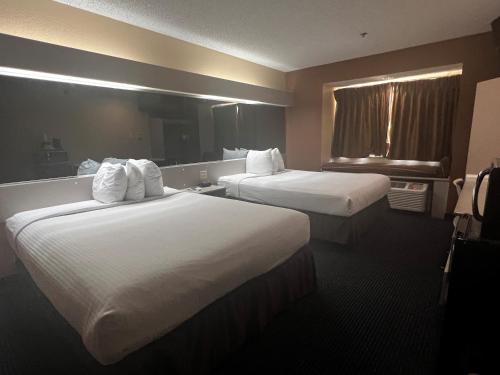 Nassau BayにあるMicrotel Inn & Suites by Wyndham Houston/Webster/Nasa/Clearlakeのベッド2台と窓が備わるホテルルームです。