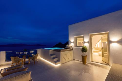 balcón con bañera, mesa y sillas en Santorini View Studios - Firostefani Caldera, en Firostefani