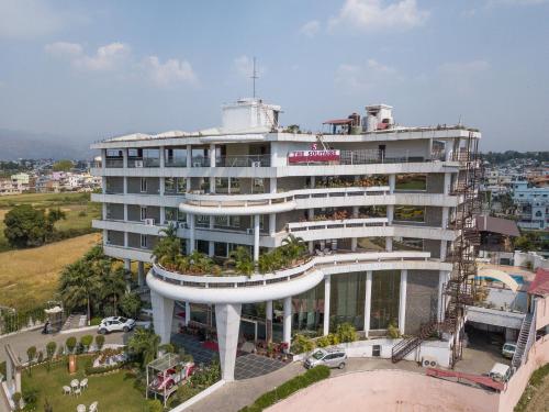 a large white building with plants on it at Pride Premier Solitaire in Dehradun