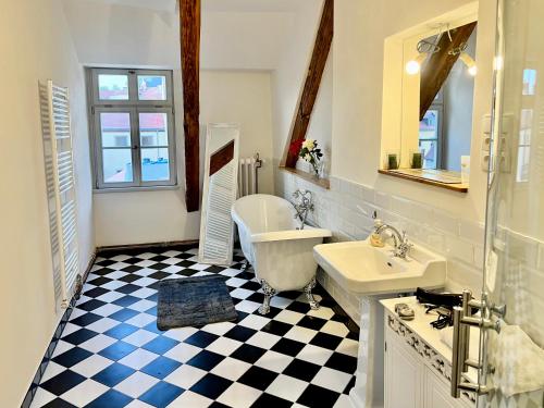 baño con suelo a cuadros en blanco y negro en Oswald Hempel 5 Zimmermaisonette und 3 Zimmer Loftwohnung, en Zittau