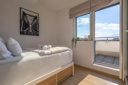 a bedroom with a bed and a large window at Starter 24 Wrocław in Wrocław