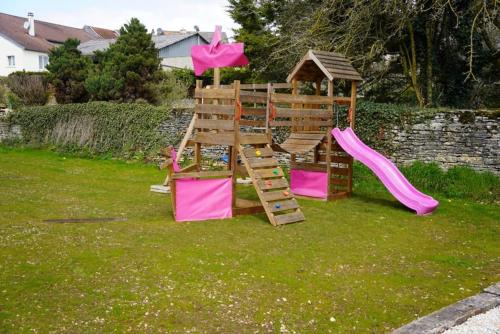 a playground with a slide in a yard at Gîte de l’Ambiance in Francheville