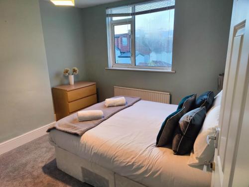 1 dormitorio con cama con almohadas y ventana en Beachgrove House, en Bristol