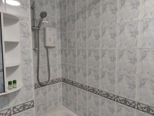 a bathroom with a shower with a shower head at Beachgrove House in Bristol