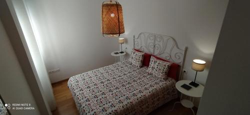 a small bedroom with a bed and a lamp at Trebol Trail Mountain La Palma Junto a Caracol in Tazacorte