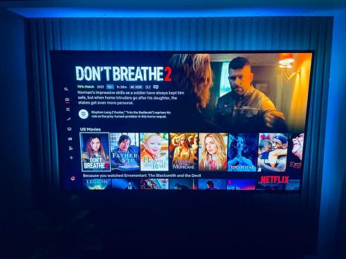 a television screen with a movie poster on it at Cozy Condo with Surround Sound for Netflix in Manila