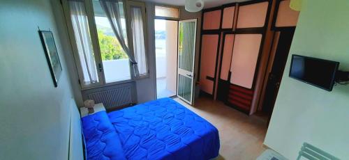 una camera con un letto blu e una finestra di Villa Principe a Bacoli