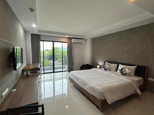 una camera con un grande letto e un balcone di We Grand Ever 9 a Nakhon Ratchasima