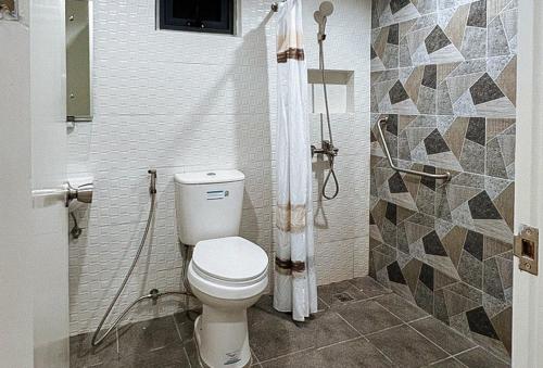 a bathroom with a toilet and a shower at Lea Robert Hotel Angeles Pampanga by RedDoorz in Angeles