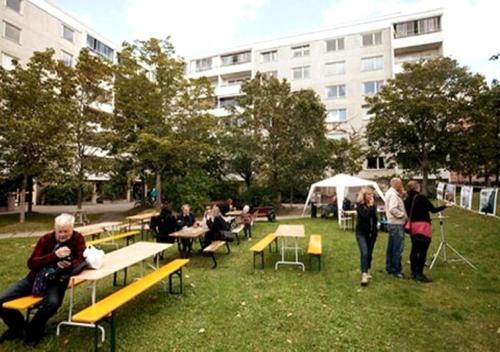 Eine Gruppe von Menschen, die auf Bänken in einem Park sitzen in der Unterkunft Casa South in Stockholm