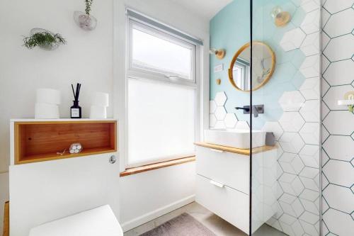 a bathroom with a toilet and a window at Enchanting 3 bedroom house with garden in Leyton in London