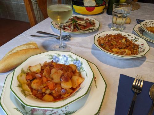 a table with plates of food and a glass of wine at Casa Rural Bilbao Caserio Gondra Alquiler Habitaciones in Mungia