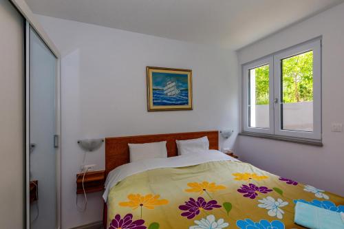 een slaapkamer met een bed met een kleurrijke deken bij Apartment "Villa M" in Kostrena