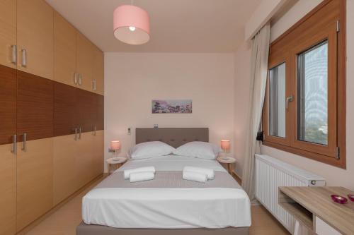 a bedroom with a large white bed with two tables at Majestic View Villa in Kolimbia